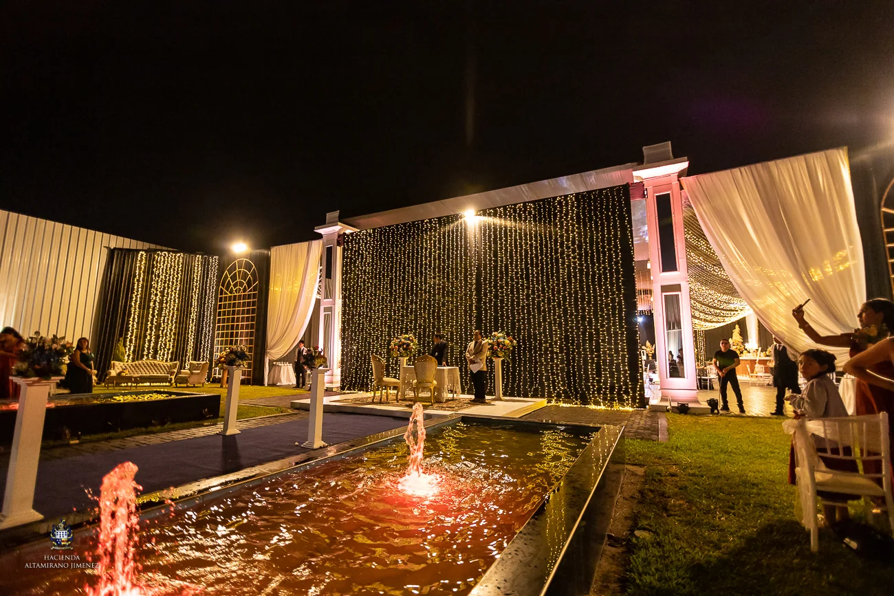 Estanque y espacios de recepción iluminados durante la noche