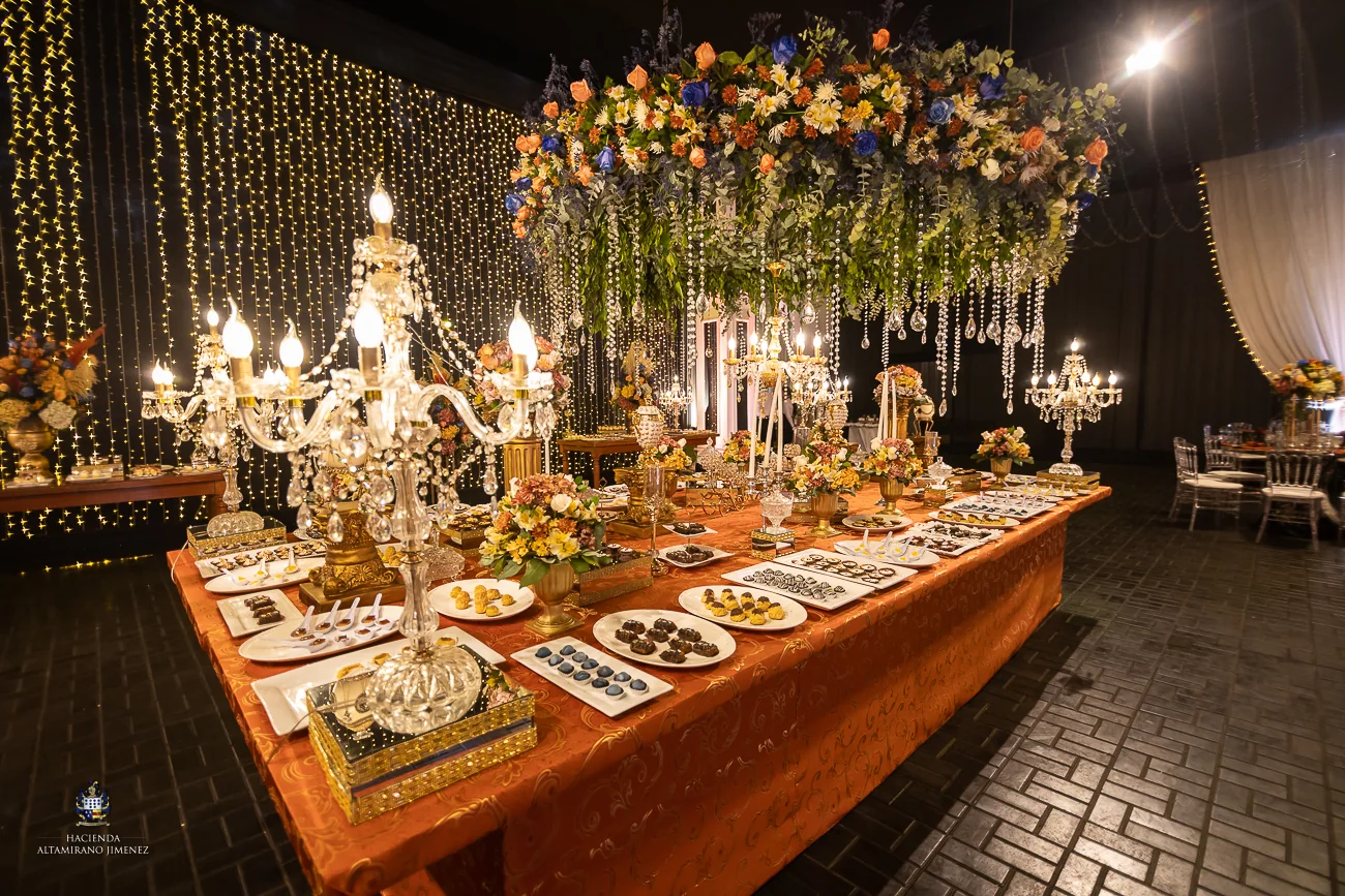 Mesa de banquete con flores, velas y platos preparados