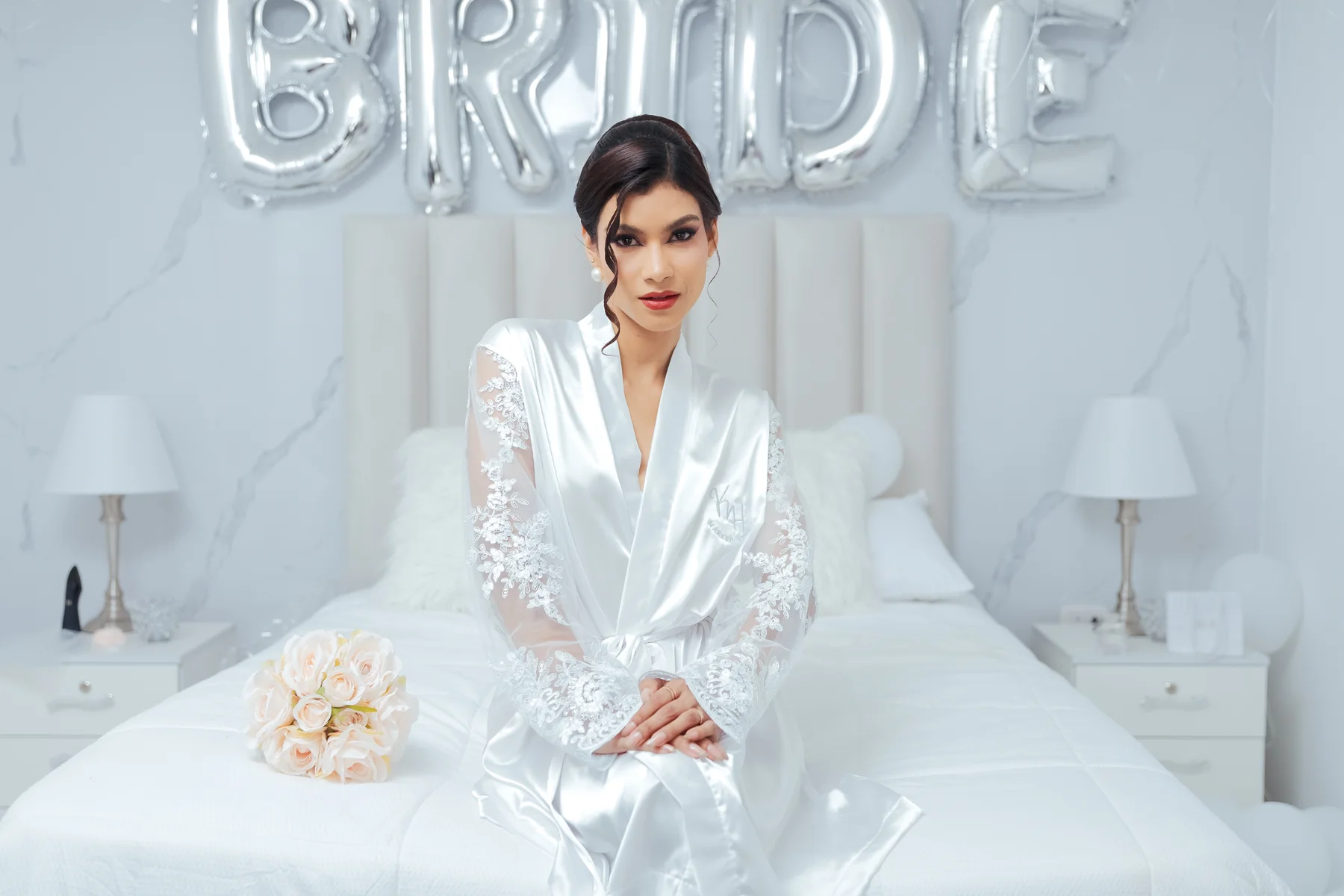 Novia sentada durante sus preparativos con globos al fondo
