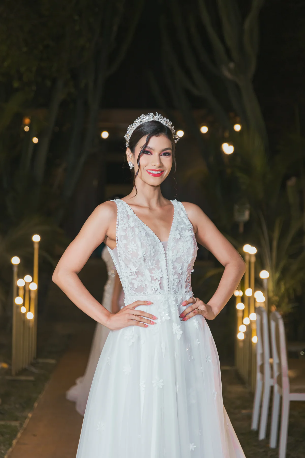 Retrato de novia con tiara y vestido blanco junto a luces cálidas