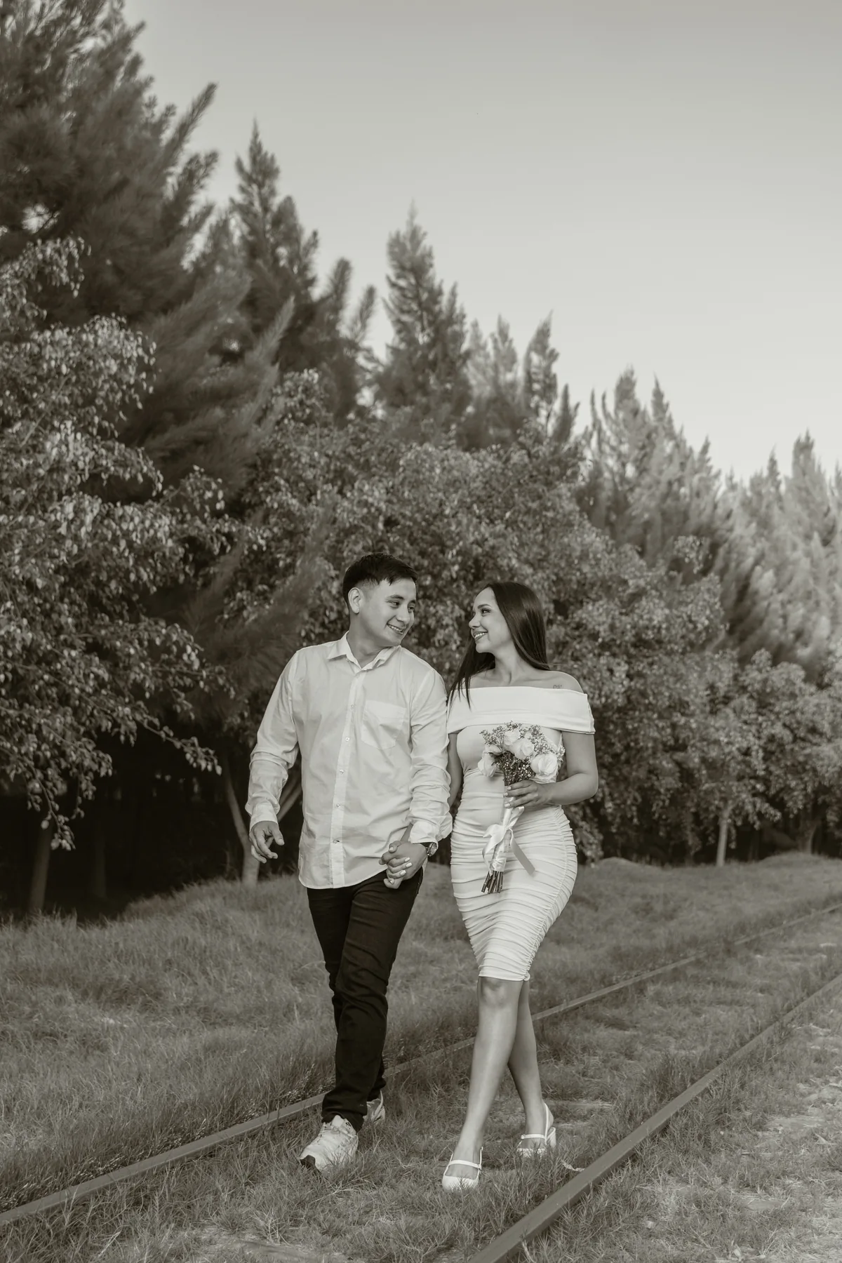 Fotografía en blanco y negro de la pareja caminando y sonriendo
